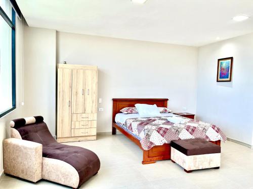 a bedroom with a bed and a chair at Edificio El Navío Luxury Suite 702 in Manta