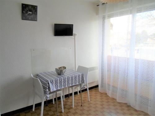 une table avec un chat assis sur elle dans une pièce dans l'établissement Charmant Mini-Studio Proche Thermes, Commerces Et Activités - Animaux Bienvenus! - FR-1-503-54, à Balaruc-les-Bains