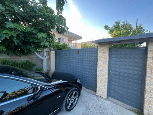 a black car parked in front of a garage at Villa Roel 2 -apartments in Vlorë
