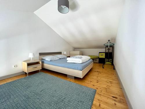 - une chambre avec un lit et un tapis bleu dans l'établissement Appartement mezzanine au calme, à La Rochelle