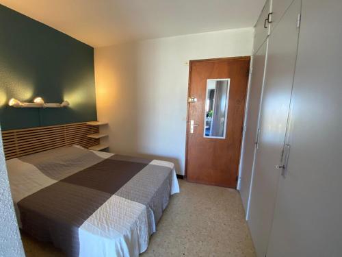 - une petite chambre avec un lit et une porte dans l'établissement Appart cosy à Balaruc-les-Bains, proche Thermes, animaux admis, climatisation - FR-1-503-101, à Balaruc-les-Bains