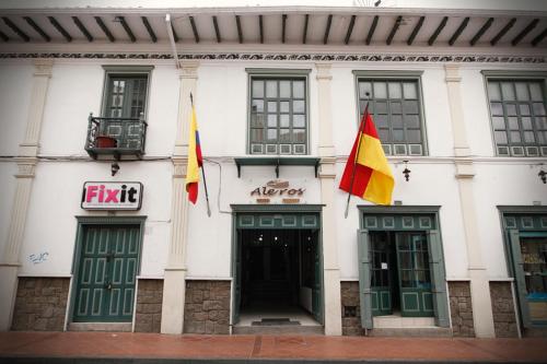 a building with two flags in front of it at Aleros Hotel Boutique in Cuenca