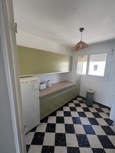 - une petite cuisine avec un sol en damier dans l'établissement Appart 5 personnes proche de la mer, à Canet