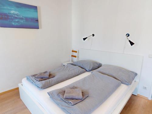 two beds in a white room with towels on them at Apartment am Traunsee in Gmunden