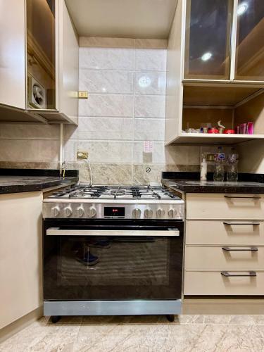 a kitchen with a black stove and cabinets at Fairy appartment in 6th Of October