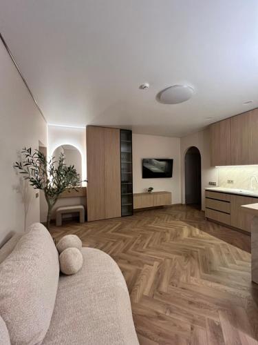 a living room with a couch and a kitchen at Apartamentai pirmame aukšte, miesto centre in Vilkaviškis