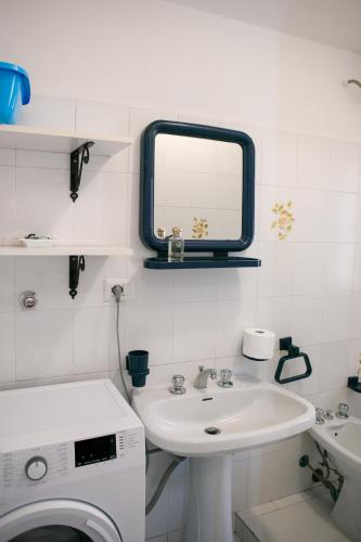 a bathroom with a sink and a washing machine at Appartamento Stefano in Scalea