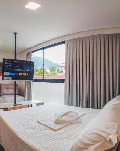 a bedroom with a bed with a flat screen tv at Loft Bamberg 201-Pomerode in Pomerode
