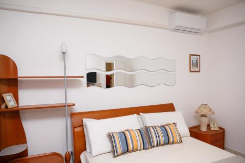 a bedroom with a bed and a white wall at Appartamento Stefano in Scalea