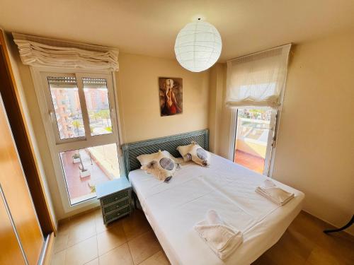 a bedroom with a large white bed and a window at Punta Cormoran by Alina365 in La Manga del Mar Menor