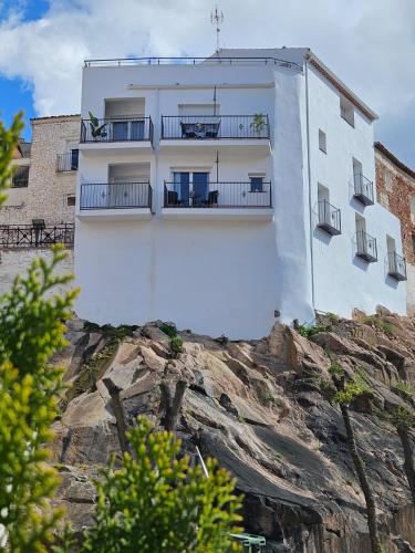 a white building on top of a rock at Apartamentos Las Riscas By Travel Home in La Puerta de Segura