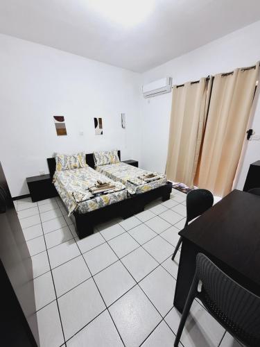 a bedroom with a bed and a table and chairs at Lovely Paceville Studio G in St. Julianʼs
