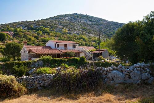 a house with a mountain in the background at Agrotourism Matusko in Neum