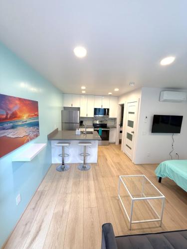 a room with a kitchen and a living room at CasaViva Sol - Modern Pet-Friendly Studio with Patio & Shared Yard - Walk to Eats & Coffee, 5 Min to Gaslamp & Beaches in San Diego