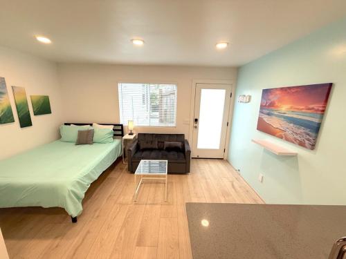 a bedroom with a bed and a couch and a window at CasaViva Sol - Modern Pet-Friendly Studio with Patio & Shared Yard - Walk to Eats & Coffee, 5 Min to Gaslamp & Beaches in San Diego