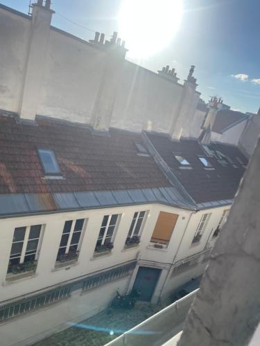 un grand bâtiment blanc avec un toit marron dans l'établissement Paris roquette appartement 1 chambre, à Paris