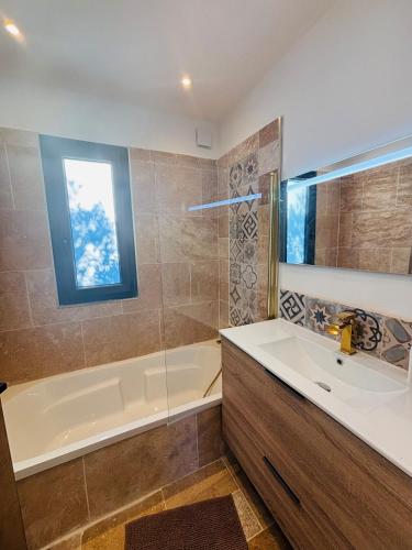 une salle de bain avec une baignoire et un lavabo et une baignoire dans l'établissement Maison à 10m de Porto Vecchio centre, à Sotta