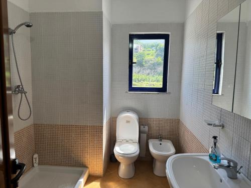 a bathroom with a toilet and a tub and a sink at Orkidea Apartments in Golem