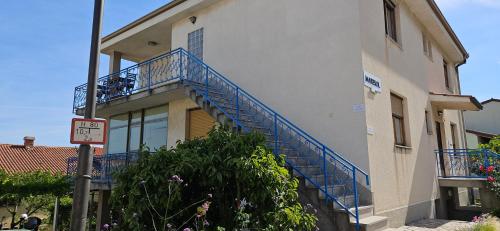 a building with a blue railing on a balcony at Rooms Laguna Maresol in Jagodje