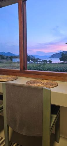 a table with chairs and a window with a view at Perivleptos ΙI in Perdhika