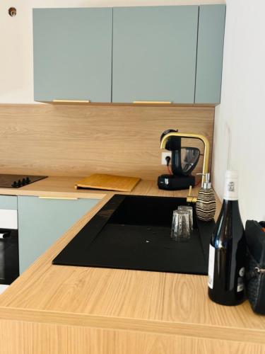 - une cuisine avec un comptoir et une bouteille de vin dans l'établissement Maison à 10m de Porto Vecchio centre, à Sotta