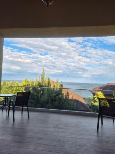a view of the ocean from a balcony with two chairs at Chayka Resort in Odesa