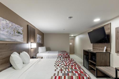 a hotel room with two beds and a flat screen tv at Red Roof Inn Pharr - McAllen in Pharr