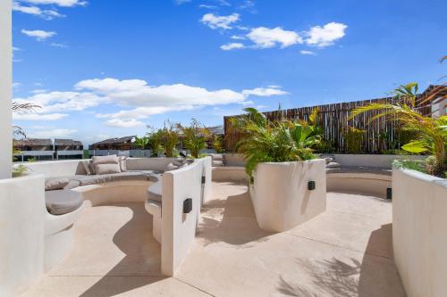 an outdoor patio with white furniture and plants at Tropical getaway in Tulum with private pool in Tulum