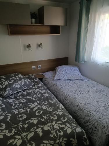 une petite chambre avec un lit et une fenêtre dans l'établissement Mobil-home, à Bias