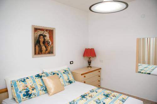 a bedroom with a bed and a painting on the wall at Appartamento LUX in Scalea