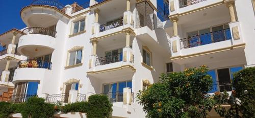 a white apartment building with balconies and trees at Sharm hills sea view in Sharm El Sheikh