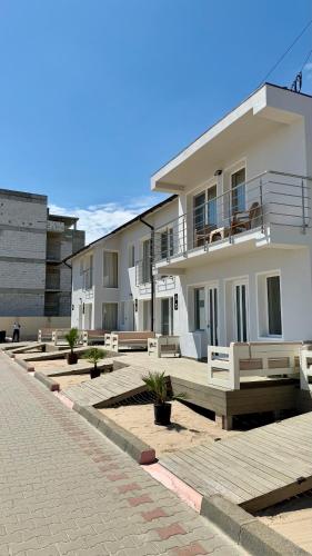 a large white building with benches in a courtyard at Vila Plaja Azur in Eforie Nord