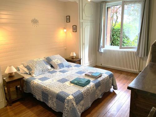 une chambre avec un lit avec une couverture bleue et blanche dans l'établissement T3 dans villa 
