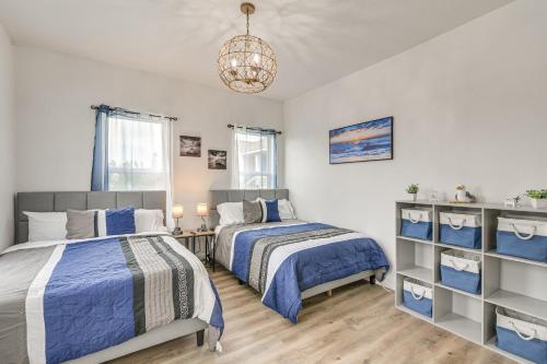 a bedroom with two beds and a chandelier at Backyard Movie Nights! Galveston Beach Retreat in Galveston