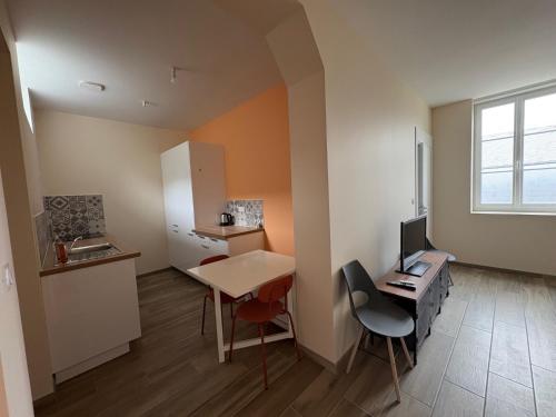 a small kitchen with a desk and a table with a computer at Les Paddocks du Damier Manceau in Marigné-Laillé