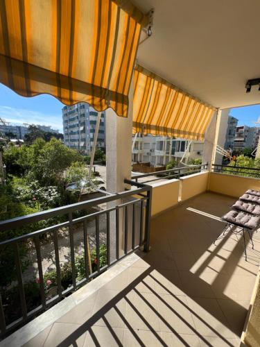 a balcony with a chair and an umbrella at Pishat e Buta Apartment Golem in Golem