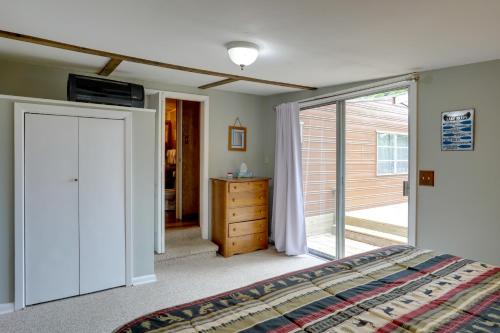 a bedroom with a bed and a sliding glass door at Greers Ferry Lake Escape Cabin with Pool Access in Higden