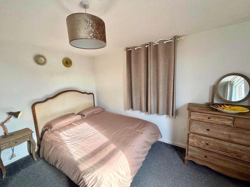 a bedroom with a bed and a dresser and a mirror at The Oxford Veranda in Oxford