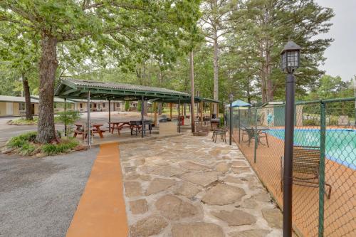 a patio with tables and chairs next to a pool at 1 Mi to Greers Ferry Lake Cabin with Pool Access in Higden
