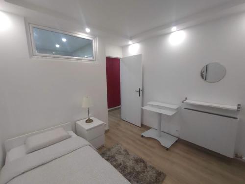 - une chambre blanche avec un lit et un lavabo dans l'établissement 4 min walk to metro, 3 bedrooms &Salon, La Défense, à Courbevoie