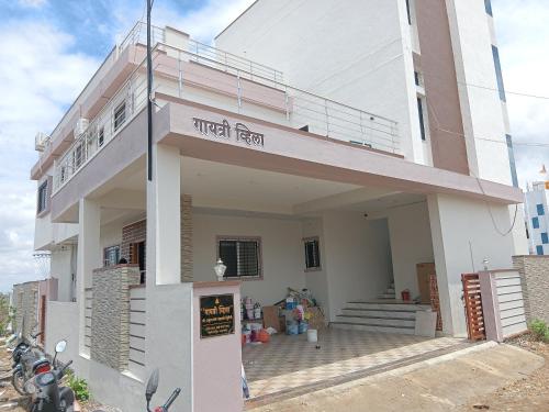 a white building with a sign that reads metal farm at Gayatri bhakt niwas in Akalkot