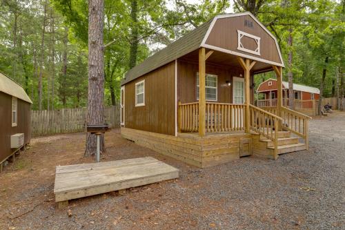 a cabin in the woods with a porch and a bench at Romantic Escape in Greers Ferry Less Than 1 Mi to Lake in Higden
