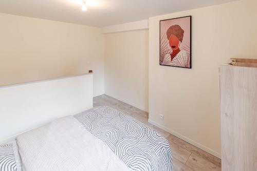 une chambre avec un lit et un tableau au mur dans l'établissement Appartement F2 centre ville, à Auxerre
