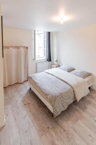 une chambre avec un grand lit avec un plancher en bois dans l'établissement Appartement F2 centre ville, à Auxerre