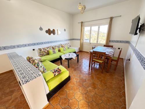 a living room with a green couch and a table at Résidence chatt Cabo Negro Appt B3 in Tetouan