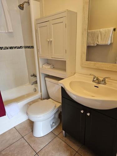 a bathroom with a white toilet and a sink at Motel de l'Outlet in Magog-Orford