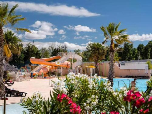- une piscine dans un complexe avec toboggan dans l'établissement Mobil Home CAMPING LES SABLES DU MIDI, à Valras-Plage