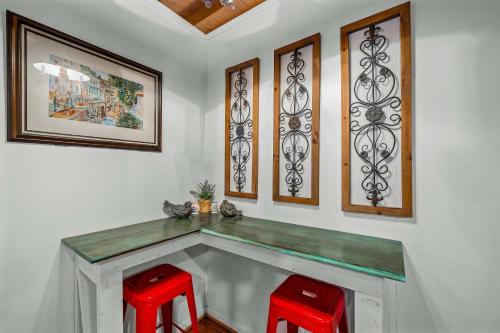 a counter with two red stools in a room at Mountain Treehouse - Magpie Nest in Mentone