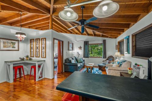 a living room with a ceiling fan and a table at Mountain Treehouse - Magpie Nest in Mentone