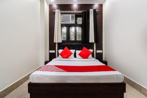 a bedroom with a large bed with red pillows at Hotel O Chandra in Lucknow